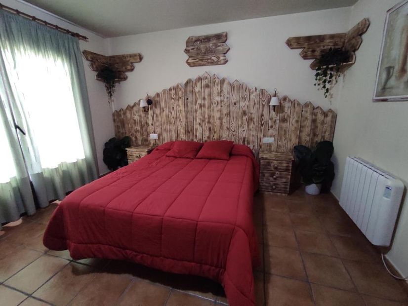 Casa Rural los Alisos dormitorio de matrimonio con su cama de manta roja