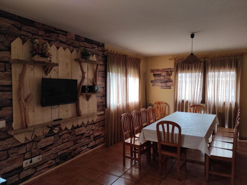 Casa Rural los Alisos sala de estar con su tele y mesa larga