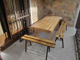 Casa Rural los Alisos mesa de madera con banquetas en terraza