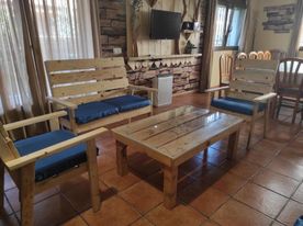 Casa Rural los Alisos sala de estar con su tele de fondo una mesa y sus asientos